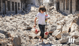 مشهد لطفلة تحاول جمع ما تبقّى من ألعابها تحت ركام منزلها,16-6-2015 درعا.jpg